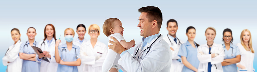 Image showing happy doctor or pediatrician with baby over blue