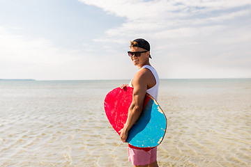 Image showing happy young man with skimboard on summer beach