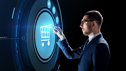 Image showing businessman with shopping cart on virtual screen