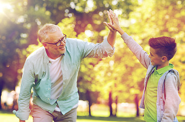 Image showing old man and boy making high five at summer park