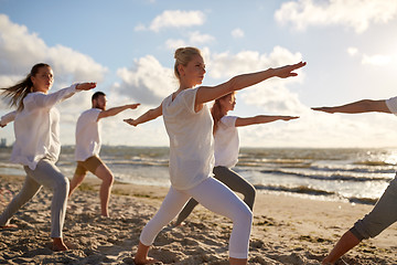 Image showing group of people making yoga exercises on beach