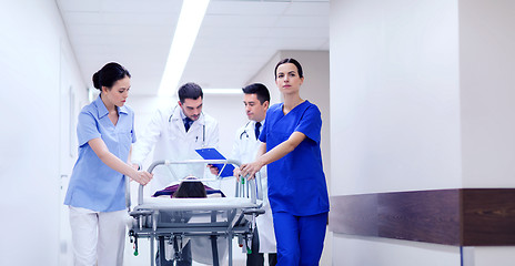 Image showing medics with woman on hospital gurney at emergency