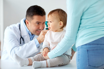 Image showing doctor with otoscope checking baby ear at clinic