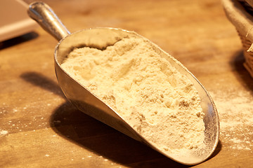 Image showing flour in bakery scoop on wooden kitchen table