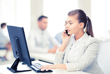 Image showing businesswoman with smartphone in office