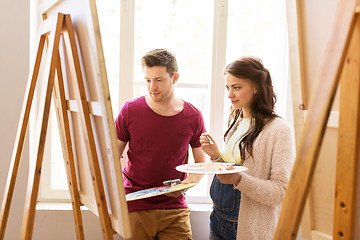 Image showing artists with brushes painting at art school