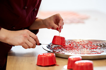 Image showing chef serving mirror glaze cakes at pastry shop