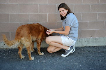 Image showing Female feeding her dog.