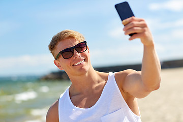 Image showing man taking selfie by smartphone on summer beach