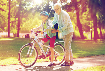 Image showing grandfather and boy with bicycle at summer park