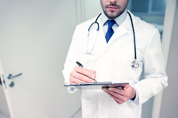 Image showing close up of doctor with clipboard at hospital