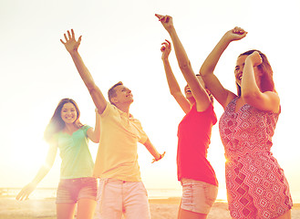 Image showing smiling friends dancing on summer beach