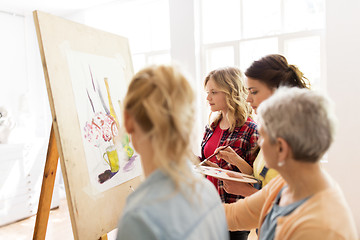 Image showing women with easel and palettes at art school