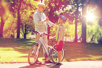 Image showing grandfather and boy with bicycle at summer park