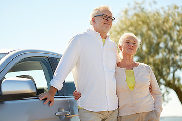 Image showing happy senior couple hugging at car in summer