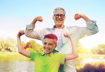 Image showing happy grandfather and grandson showing muscles