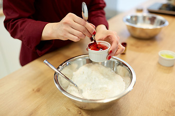 Image showing chef hands adding food color into bowl with flour