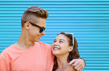 Image showing happy teenage couple hugging over blue background