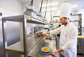 Image showing happy male chef cooking food at restaurant kitchen