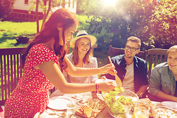 Image showing happy friends having dinner at summer garden party