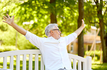 Image showing happy senior man sitting on bench at summer park
