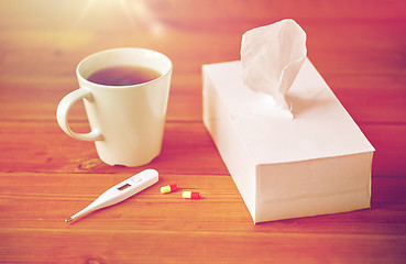 Image showing cup of tea, paper wipes and thermometer with pills