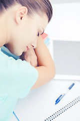 Image showing tired student sleeping on stock of books