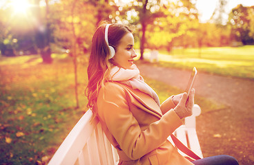 Image showing woman with tablet pc and headphones in autumn park