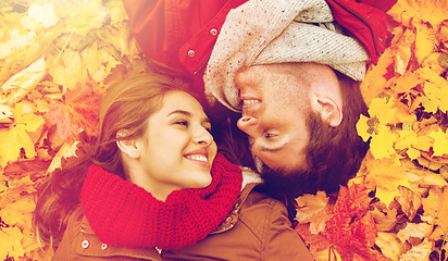 Image showing close up of smiling couple lying on autumn leaves