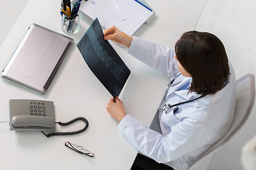 Image showing doctor with spine x-ray sitting at table