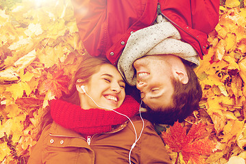 Image showing close up of smiling couple lying in autumn park