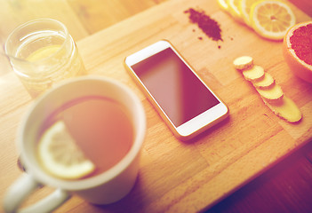 Image showing smartphone with cup of lemon tea, honey and ginger