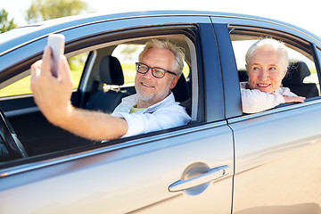 Image showing senior couple in car taking smartphone selfie 