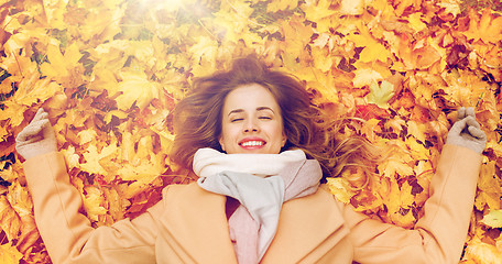 Image showing beautiful happy woman lying on autumn leaves