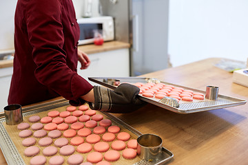 Image showing chef with macarons on oven tray at confectionery