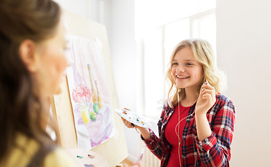 Image showing student girls with easel painting at art school