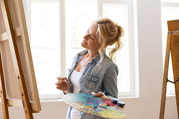 Image showing woman artist with easel painting at art school