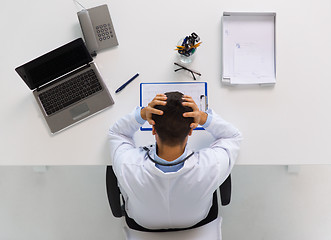 Image showing doctor with cardiogram and laptop at clinic