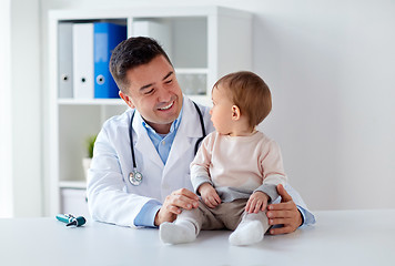 Image showing happy doctor or pediatrician with baby at clinic