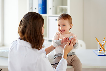 Image showing happy doctor or pediatrician with baby at clinic