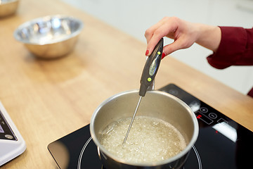 Image showing chef measuring temperature in syrup at kitchen