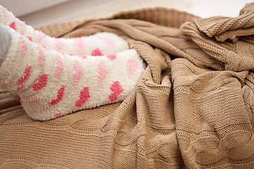 Image showing woman or girl feet in socks and knitted plaid