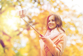 Image showing woman taking selfie by smartphone in autumn park