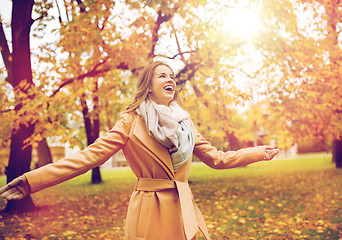 Image showing beautiful happy young woman walking in autumn park