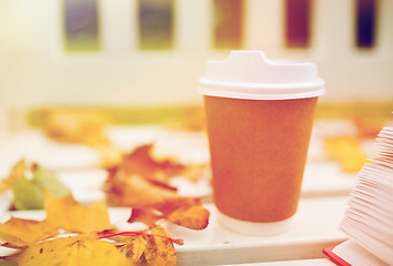 Image showing coffee drink in paper cup on bench at autumn park