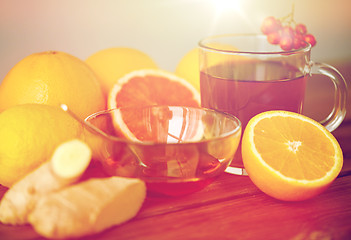 Image showing tea with honey, lemon and ginger on wood