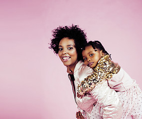 Image showing young pretty african-american mother with little cute daughter hugging, happy smiling on pink background, lifestyle modern people concept 