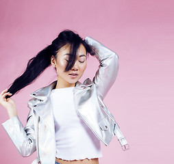 Image showing young pretty smiling asian korean girl wearing modern fashion clothers on pink background, lifestyle people concept 