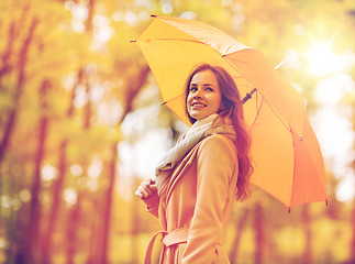 Image showing happy woman with umbrella walking in autumn park