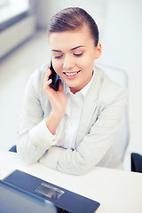 Image showing businesswoman with smartphone in office